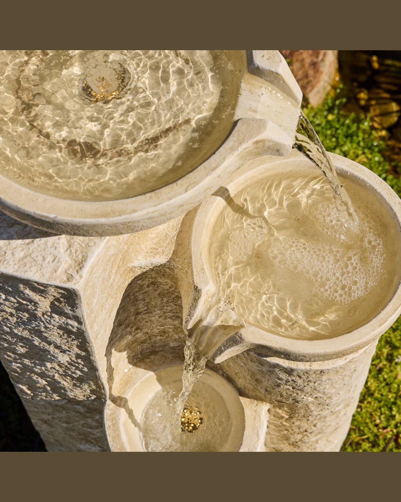 Echo Falls Stone water fountain with flowing water in a garden setting