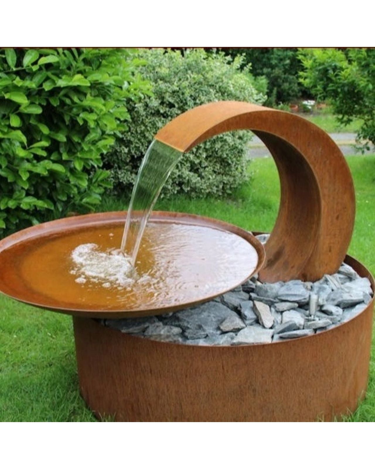 Corten Steel Rustic Curved Spout Outdoor Water Feature in garden setting