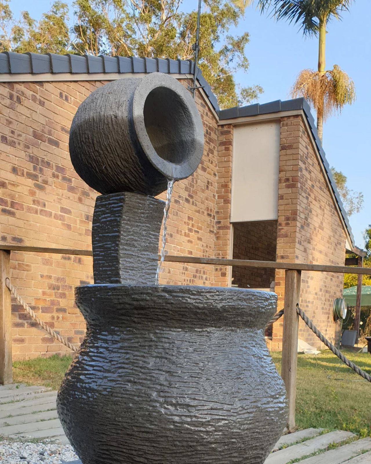 Decorative stone vase water feature in front of a brick building