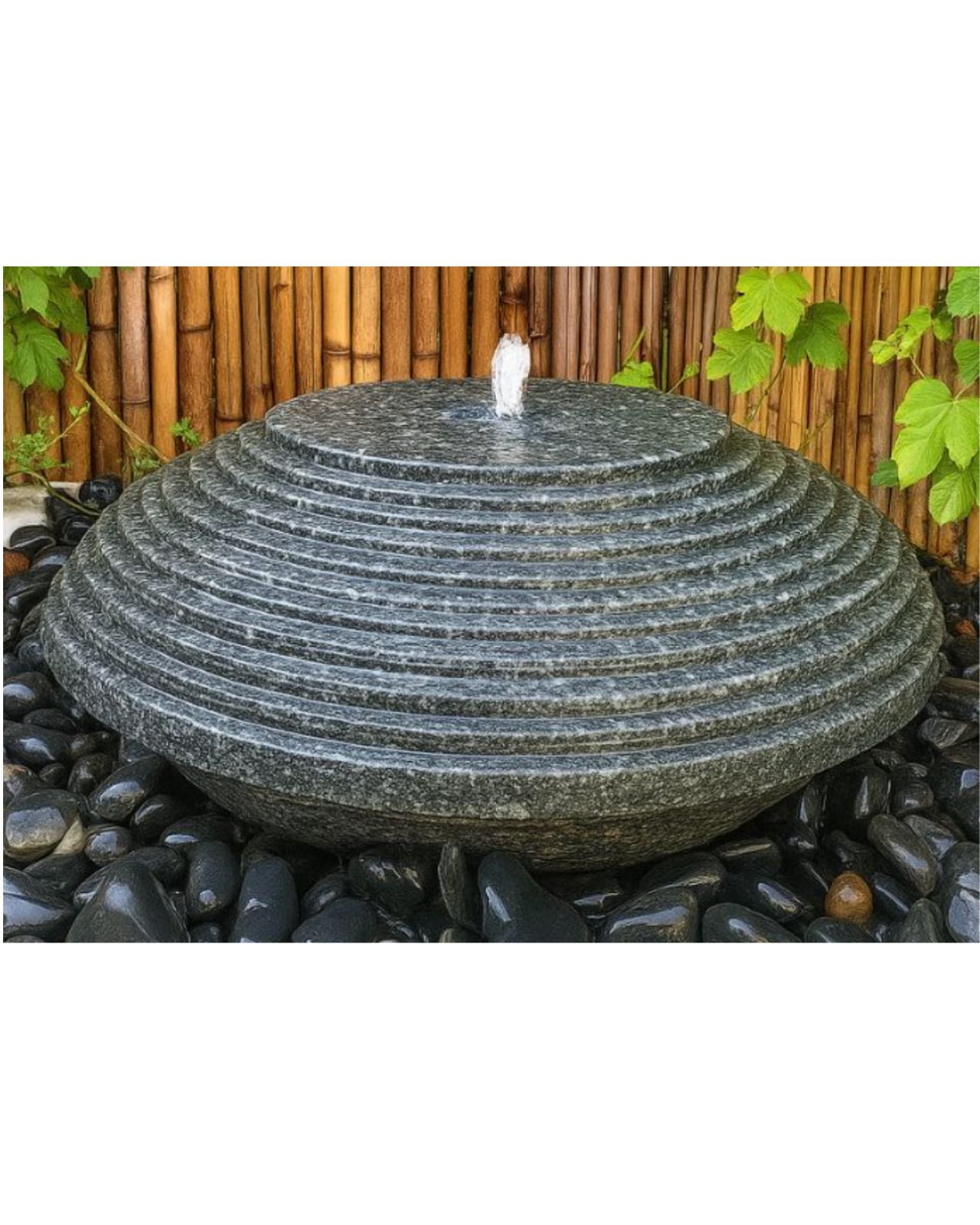 Japanese Stone water fountain with bamboo and greenery in the background
