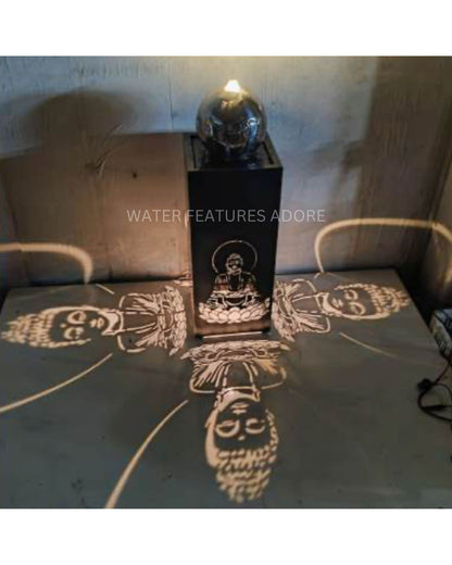 Decorative water feature with projected buddha faces on a stone surface.