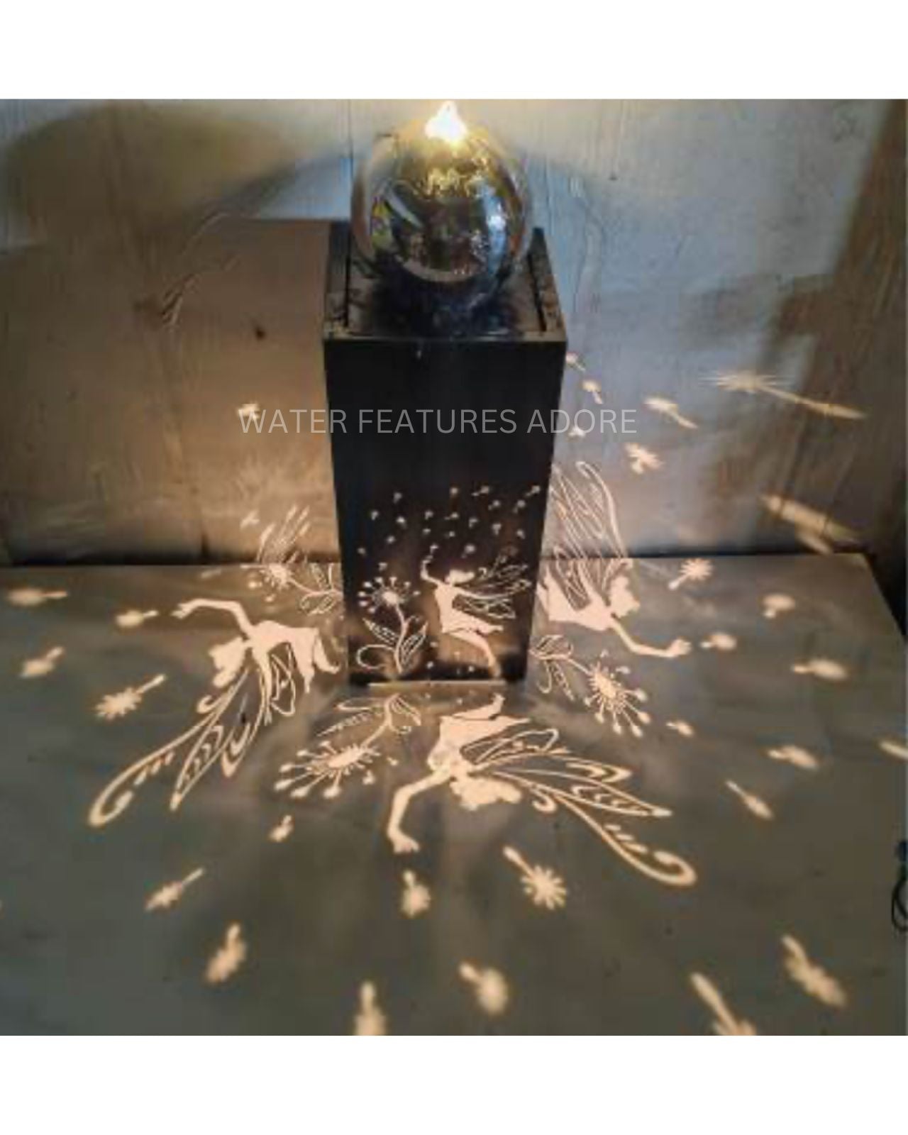 Decorative water feature with fairy projections on a wall