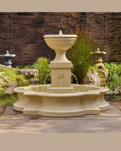 Stone fountain in a garden setting with rocks and plants