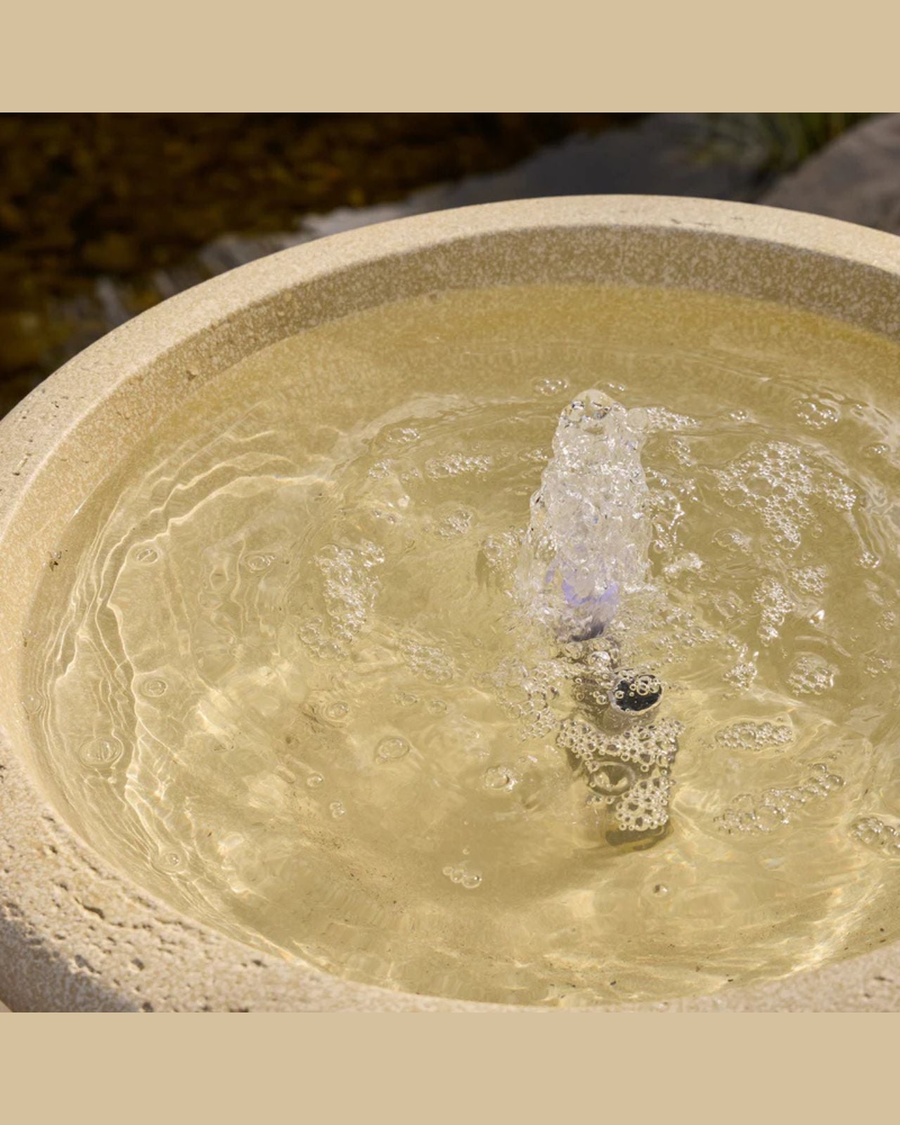 Stone water fountain with water flowing into a basin