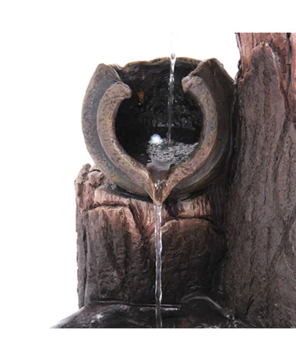 Decorative water fountain with stone-like design on a white background
