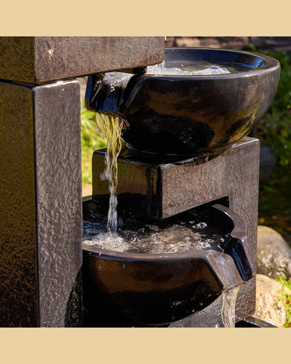 Outdoor cascading water fountain with water flowing into a bowl