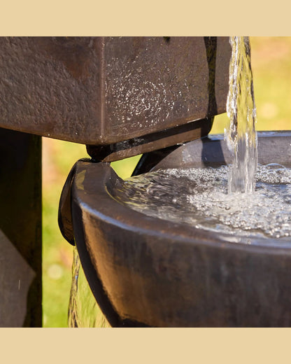 Close-up of a cascading water fountain with water flowing into a basin.
