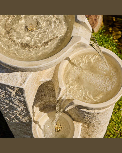Echo Falls Stone water fountain with flowing water in a garden setting