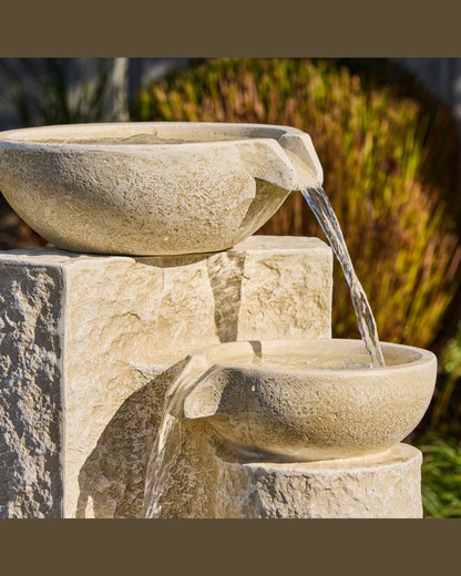Echo Falls Stone water fountain with three tiers in a garden setting