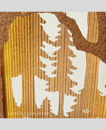 Wall water feature with cut-out shapes resembling trees and leaves on a textured background.