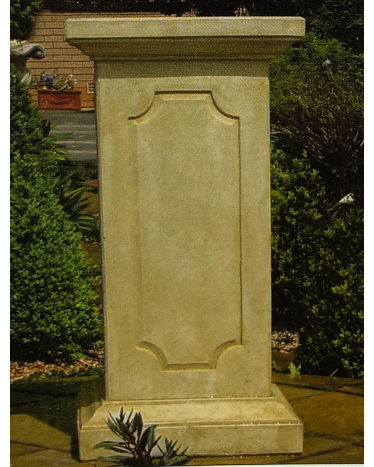 Decorative concrete pedestal in a garden setting