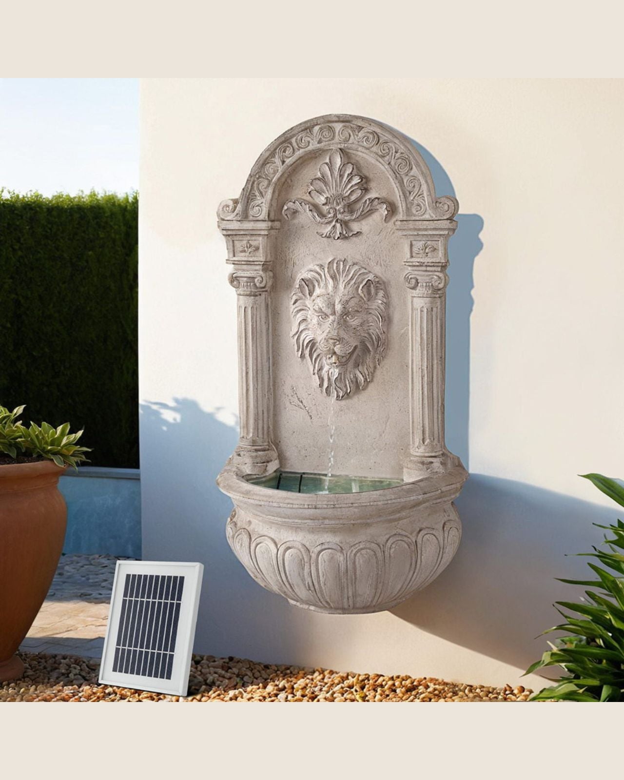 Decorative stone wall fountain with solar panel on a white wall background