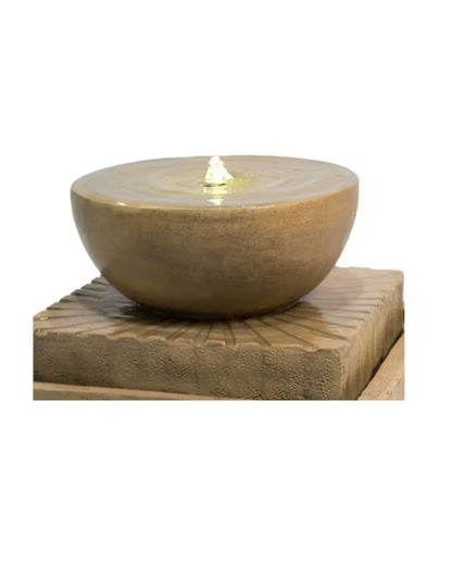 Decorative stone bowl fountain with a light inside on a matching stone base 