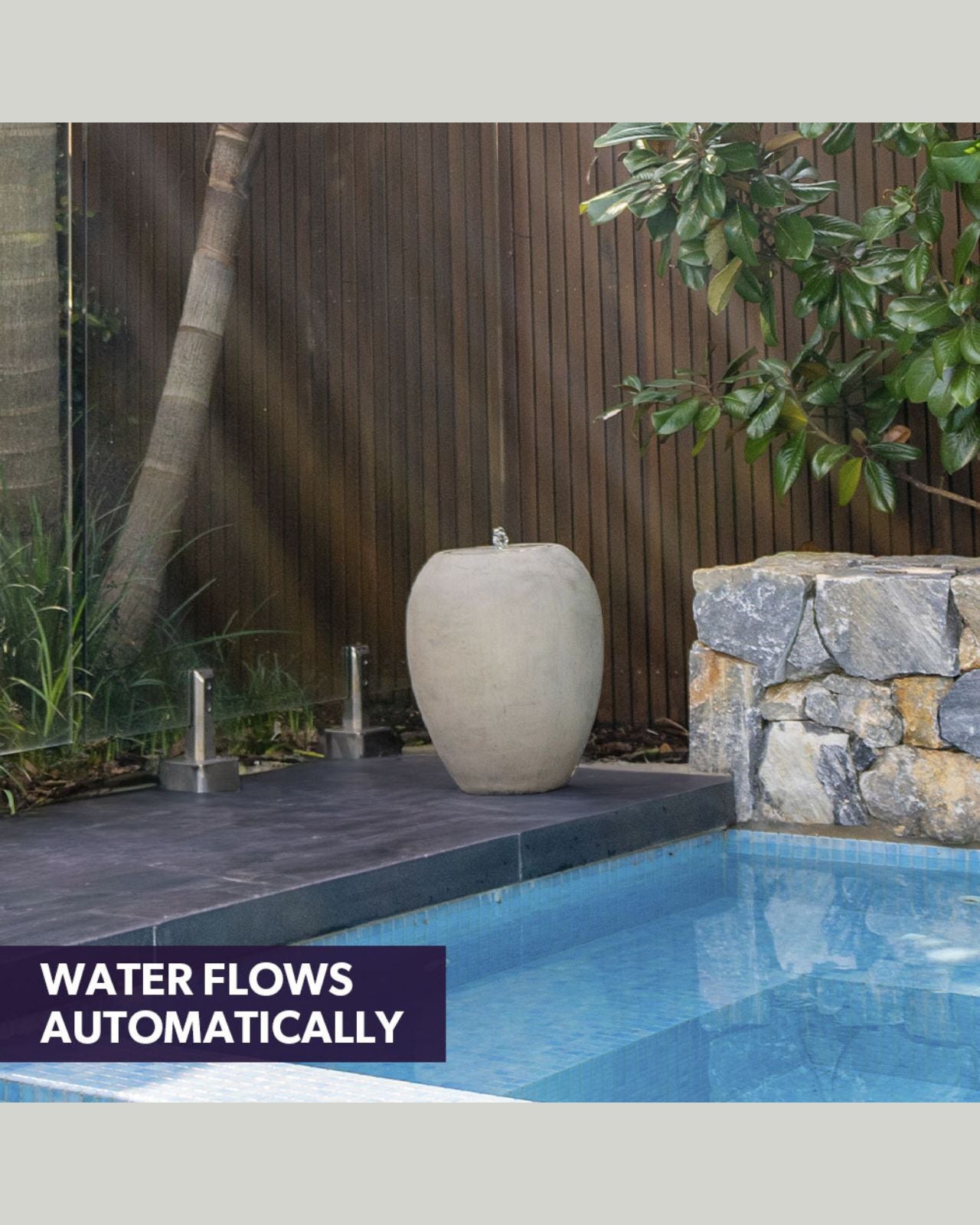 Decorative stone urn water feature by a pool with text 'Water flows automatically'