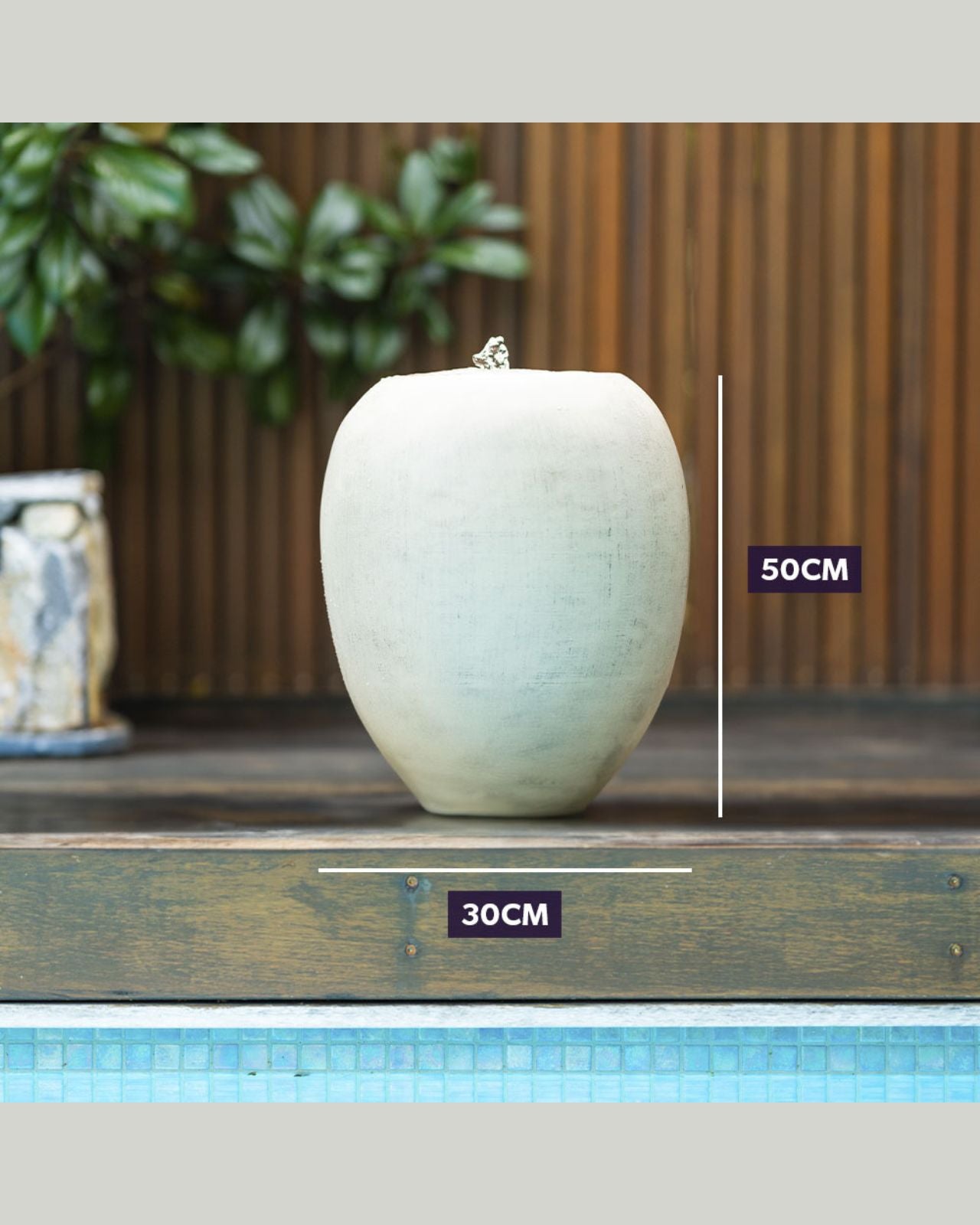 White ceramic vase water feature on a wooden surface with dimensions indicated