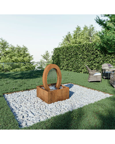 Corten steel water feature in a garden setting with greenery and a seating area.