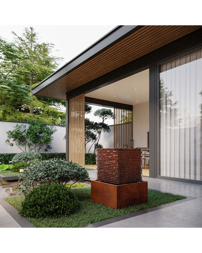 Modern house exterior with a garden and decorative brick structure water feature.