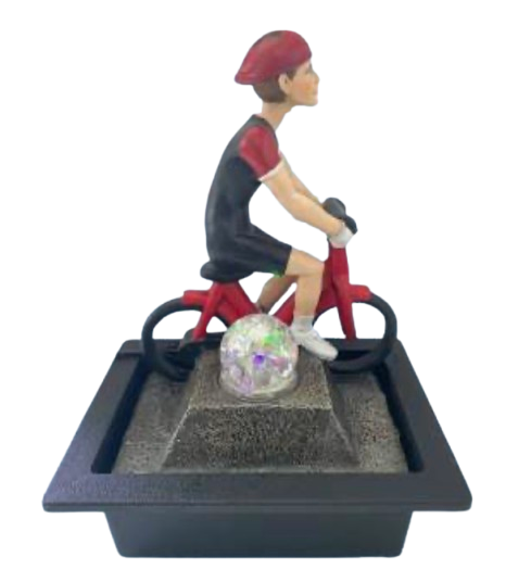 A miniature tabletop fountain of a boy riding a red bicycle on a black base with a small clear ball in the center.