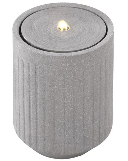 Gray textured candle water feature with a small flame on a white background