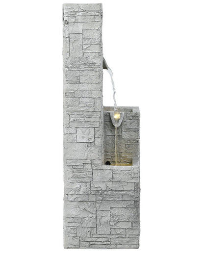 Stone-patterned wall-mounted water feature with light on a white background