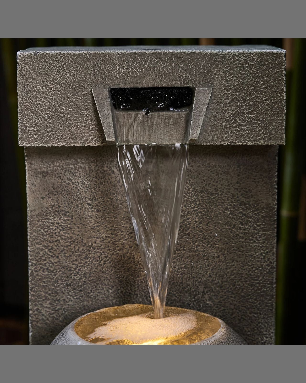Water fountain with water flowing out, set against a dark background.