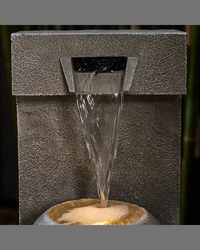 Water fountain with water flowing out, set against a dark background.