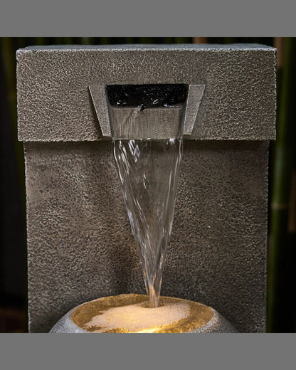 Water fountain with water flowing out, set against a dark background.