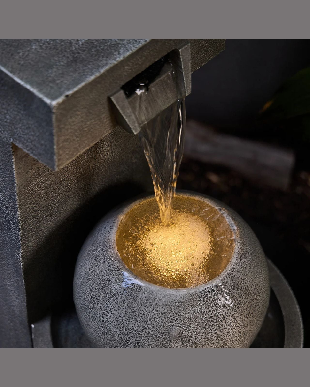 Water being poured from a water feature into a textured container.