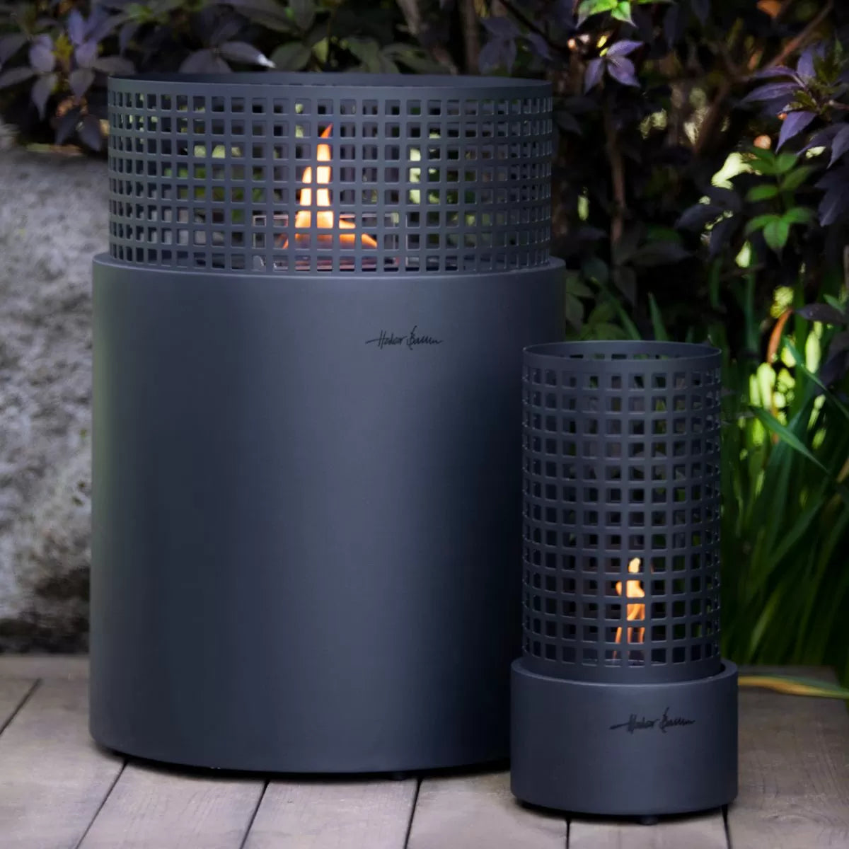Two matte dark gray outdoor flameless Tenderflame fireplaces with a grid-patterned top and visible flame inserts.