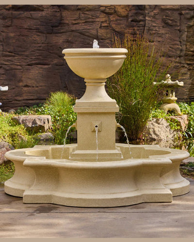 Stone garden fountain water feature against a stone wall background
